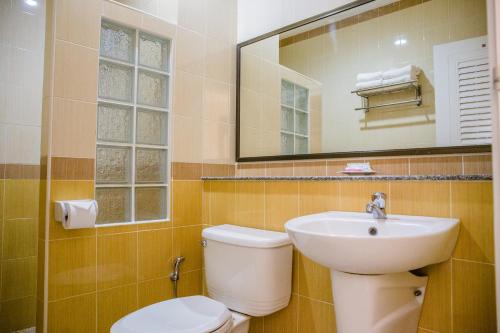 a bathroom with a toilet and a sink and a mirror at Monrawee Pavilion Resort in Phitsanulok