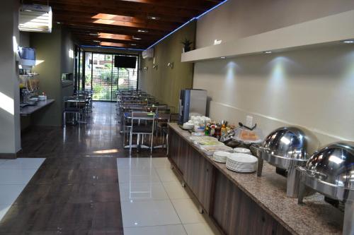 a large kitchen with tables and chairs in a restaurant at Mesami Hotel in Durban