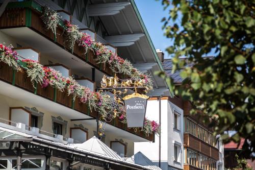 a hotel with flowerpots on the side of a building at Haller's Posthotel in Riezlern
