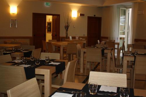 a dining room with tables and chairs in a restaurant at Domus Australia in Rome