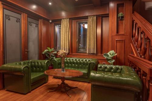 a living room with a green couch and a table at Hotel Senigallia in Skopje