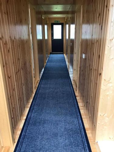 a hallway with a blue carpet in a building at Rauðsdalur in Brjánslækur