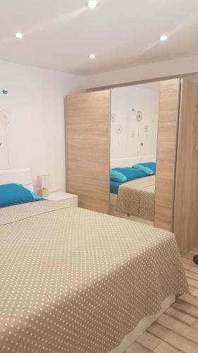 Un dormitorio con dos camas y un gran espejo. en Apartman Sevilya, en Kostrena