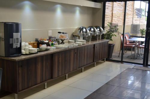a restaurant with a counter with plates and dishes at Mesami Hotel in Durban