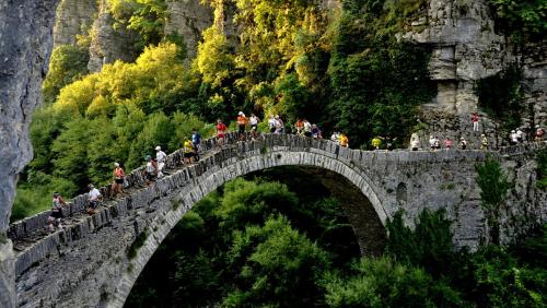 a group of people riding bikes on a stone bridge at Papaevangelou Hotel in Papigko