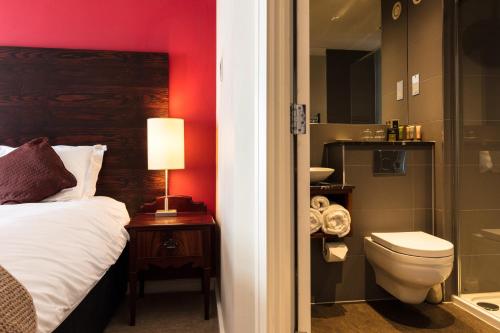 a bathroom with a bed and a toilet and a shower at Dukes Head Hotel in Croydon