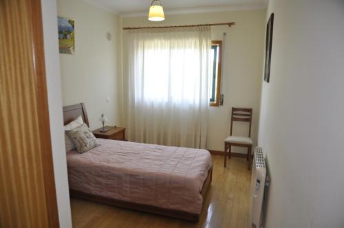 a bedroom with a bed and a window and a chair at Apartamento Algarve Holidays in Faro