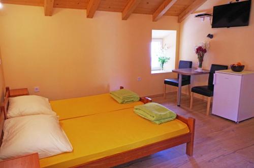 a bedroom with a large yellow bed and a table at apartman željana in Vis