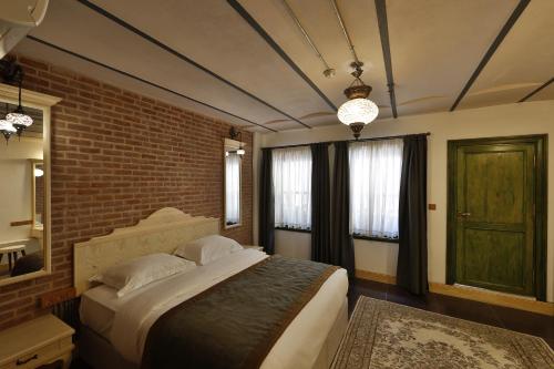 1 dormitorio con 1 cama grande y pared de ladrillo en Catirga Konak Apartments, en Estambul