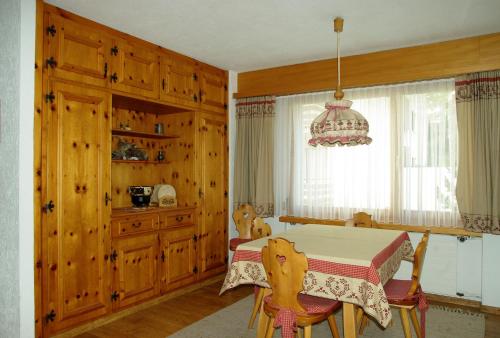 una sala da pranzo con tavolo e lampadario pendente di Ferienwohnung in Davos a Davos