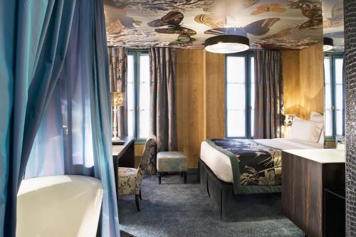 a hotel room with a bed and a desk at Hôtel Le Bellechasse Saint-Germain in Paris