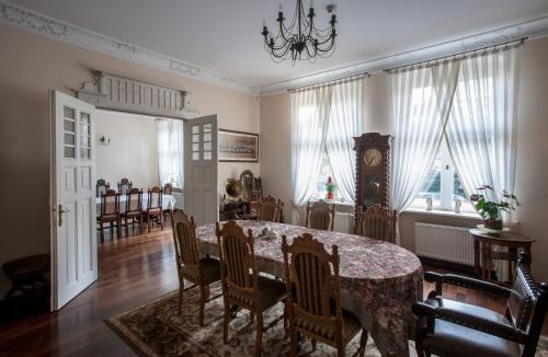 a dining room with a table and chairs and a clock at Hotel Stary Malbork in Malbork