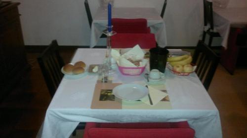 プレガンツィオールにあるWhite Chocolateの白いテーブルクロスとキャンドルが掛けられたテーブル