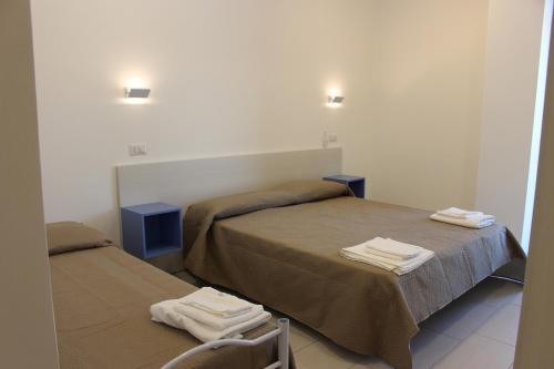 アグローポリにあるHotel La Tombolaのベッドルーム1室(ベッド2台、タオル付)