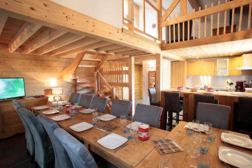 uma sala de jantar com uma longa mesa de madeira e cadeiras em Les Chalets Du Grand Galibier em Valloire