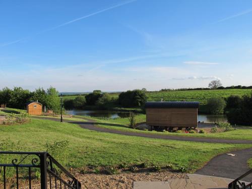 a building in a field next to a river at Fair Farm Hideaway in Waltham on the Wolds