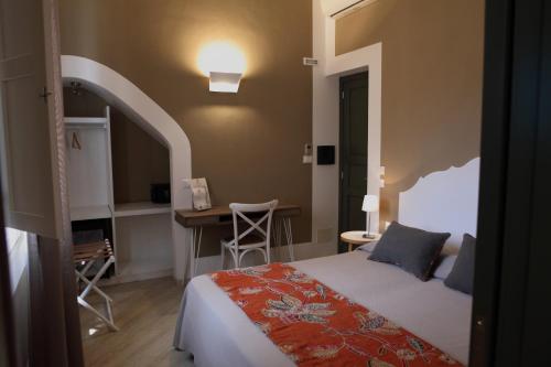 a bedroom with a bed and a desk and a table at Aegusa Hotel in Favignana