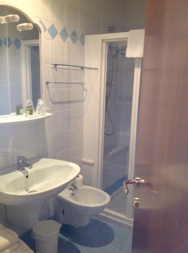 a white bathroom with a sink and a shower at Hotel Belvedere in Torri del Benaco