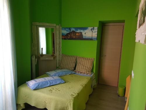 Dormitorio verde con cama y ventana en Thousand Colors, en Nápoles