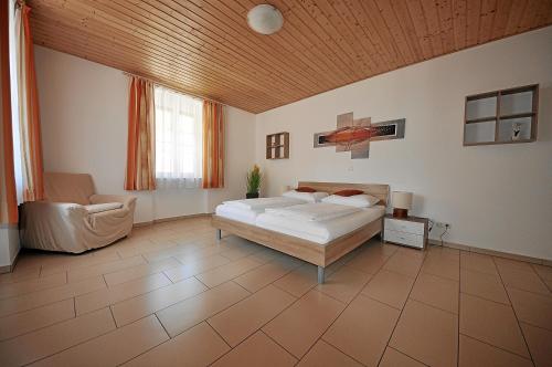 a large bedroom with a bed and a chair at Apartements Wallner in Hallstatt