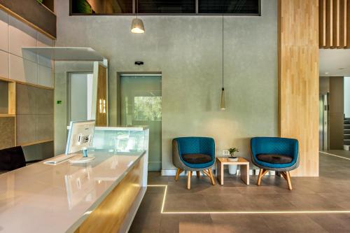 an office with two blue chairs and a desk at Mava Apartamente in Constanţa