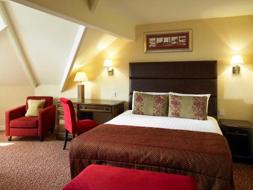 a hotel room with a bed and a desk and a chair at Imperial Hotel Blackpool in Blackpool