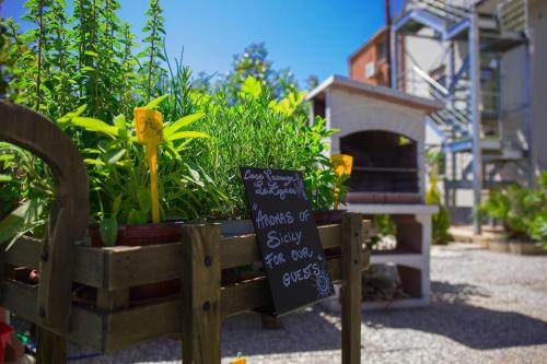 a sign in a wooden box with some plants at Le Zagare in Lascari