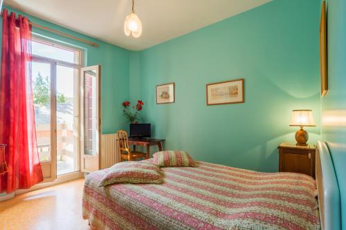 a bedroom with a bed and a sliding glass door at Chambres d'hôtes - Domaine Gigou in La Chartre-sur-le-Loir