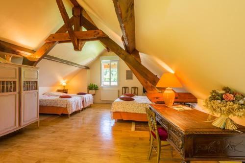 ein Schlafzimmer mit 2 Betten und einem Tisch in einem Zimmer in der Unterkunft Chambres d'hôtes - Domaine Gigou in La Chartre-sur-le-Loir