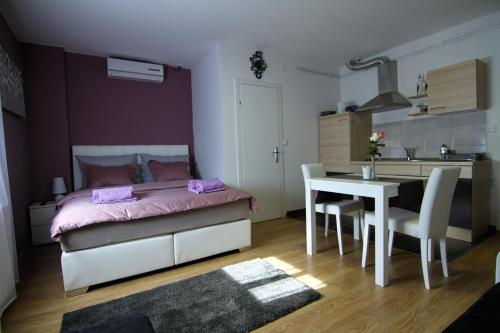a bedroom with a bed and a table and a kitchen at Apartment Mavero-Free Private Parking in Zagreb