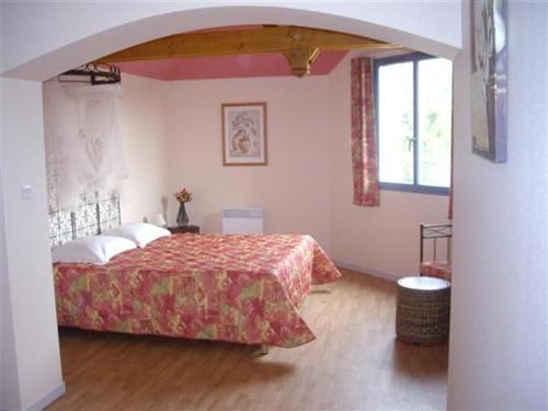 a bedroom with a bed and a large window at La Terrasse des Oliviers in Mansigné