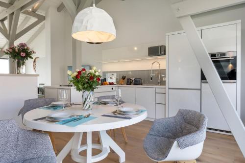 a kitchen and dining room with a white table and chairs at Alte Scheune am Focker Strom in Mursewiek