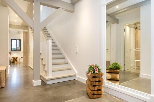 a staircase in a home with white walls at Alte Scheune am Focker Strom in Mursewiek