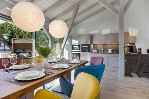 a dining room with a wooden table and colorful chairs at Alte Scheune am Focker Strom in Mursewiek