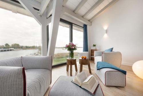 a living room with two couches and a large window at Alte Scheune am Focker Strom in Mursewiek