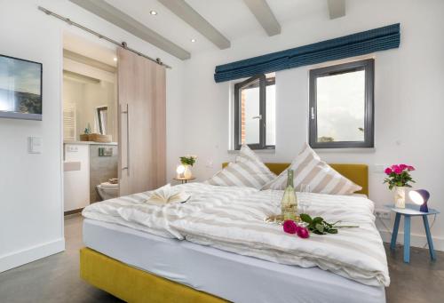 a bedroom with a large white bed with flowers on it at Alte Scheune am Focker Strom in Mursewiek
