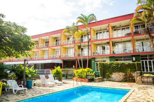 um hotel com piscina em frente a um edifício em Hotel Pelicano em Ilhabela