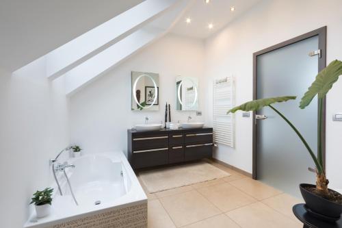 a bathroom with a large tub and a sink at Bled Apartment Kirsch in Bled