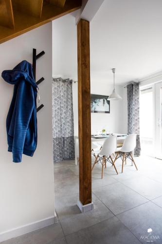 a dining room with a blue robe hanging on a wall at Domki Akacjowa Friends&Family Wellness in Łeba