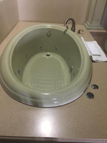 a large green bath tub in a bathroom at Weslaco Inn - Weslaco/Mercedes in Weslaco