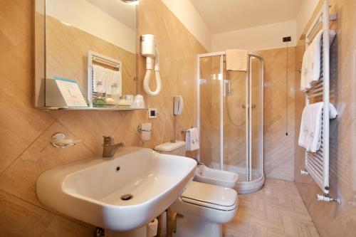 a bathroom with a sink, toilet and shower at Hotel Villa Undulna - Terme della Versilia in Cinquale
