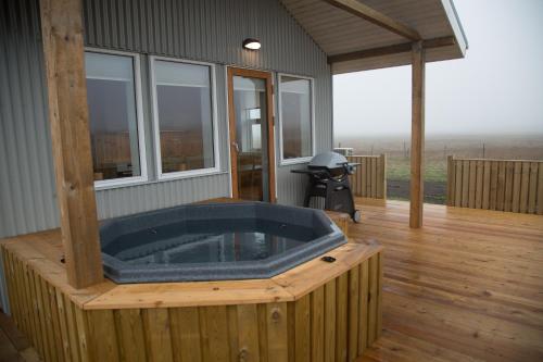 a large jacuzzi tub on a wooden deck at Eldhraun Holiday Home in Kirkjubæjarklaustur