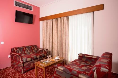 a living room with a couch and a chair at Xenophon Hotel in Athens