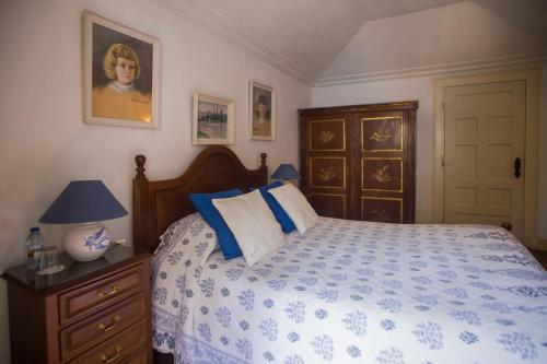 a bedroom with a bed, a desk, and a painting on the wall at Quinta de Sao Thiago in Sintra