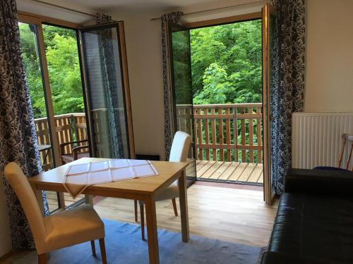a living room with a table and a balcony at Hupfmühle Pension in St. Wolfgang