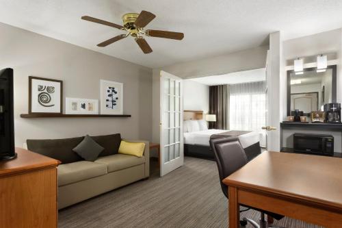 a living room with a couch and a bed at Country Inn & Suites by Radisson, Columbus Airport, OH in Columbus
