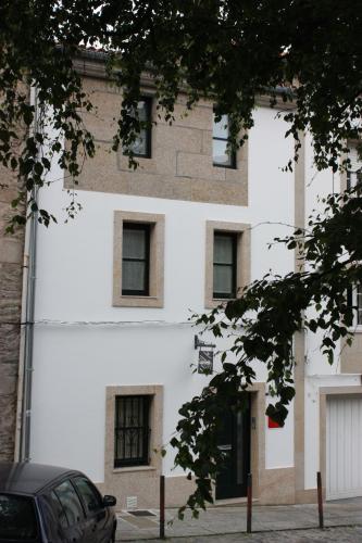 een wit gebouw met ramen aan de zijkant bij Casa Do Medio in Santiago de Compostela