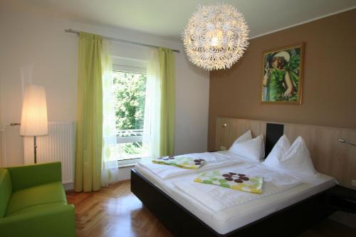 a bedroom with a large bed and a chandelier at Buchenheim Apartments in Reifnitz