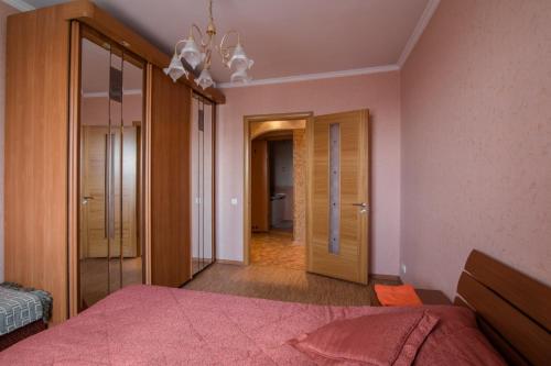 1 dormitorio con cama y lámpara de araña en Кузнецктроевский en Novokuznetsk