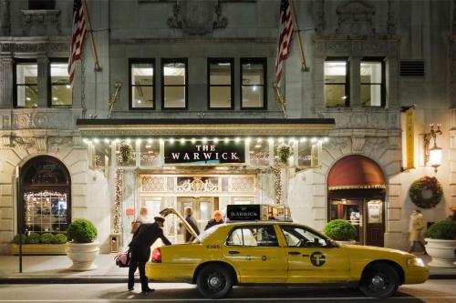 a yellow taxi cab parked in front of a building at Warwick New York in New York